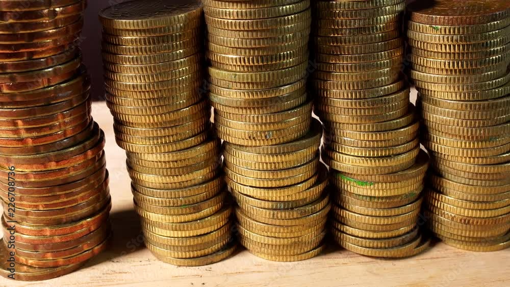 Stacks of Gold Coins isolated indoors on wooden table Stacks of Gold Coins isolated indoors on wooden table