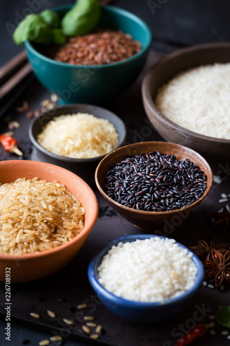 Different types of rice in bowls showing variety of colours and shapes. Shallow depth of field with selective focus on black Venere rice