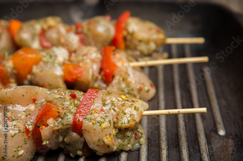 Skewers with raw meat on grill pan