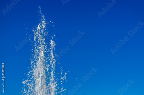 Water jet from a fountain in a park  with the blue background of the sky.