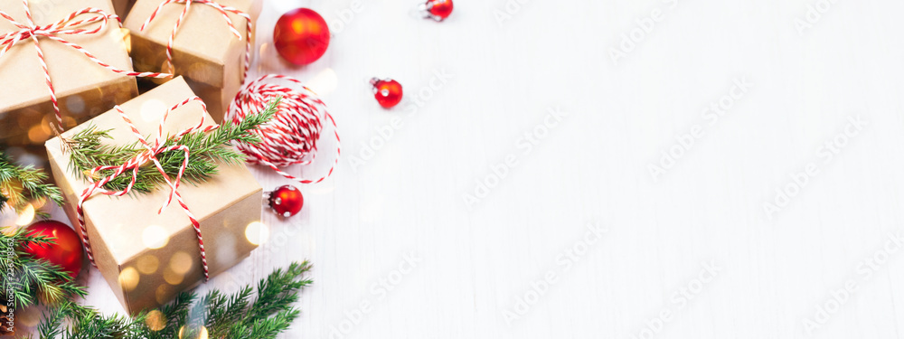 Christmas gift boxes collection with evergreen branches, candy cane Christmas rope and red Christmas balls. Angle view. Copy space, banner for website. Christmas gift boxes collection with evergreen branches, candy cane Christmas rope and red Christmas balls. Angle view. Copy space, banner for website.