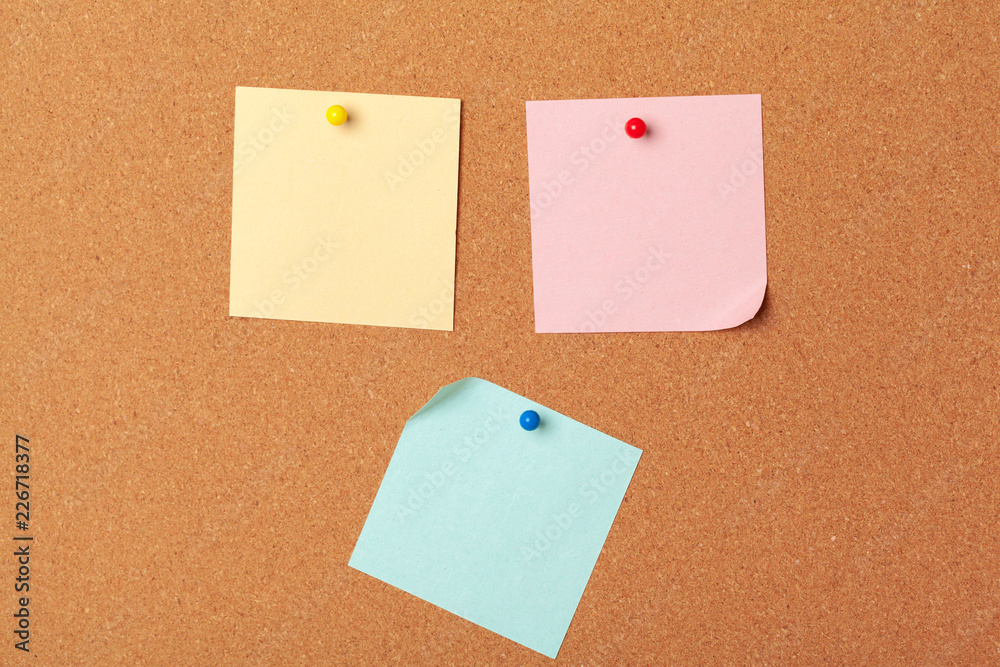 Sticky notes with pushpins and blank space on cork background. School or business concept Sticky notes with pushpins and blank space on cork background. School or business concept