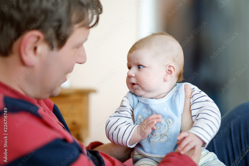 Happy proud young father with newborn baby daughter, family portrait togehter Happy proud young father with newborn baby daughter, family portrait togehter