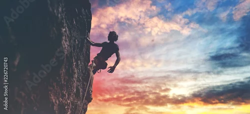 Obraz mężczyzna wspinacz odpoczynku podczas wspinaczki trudnej trasy na skalistej ścianie