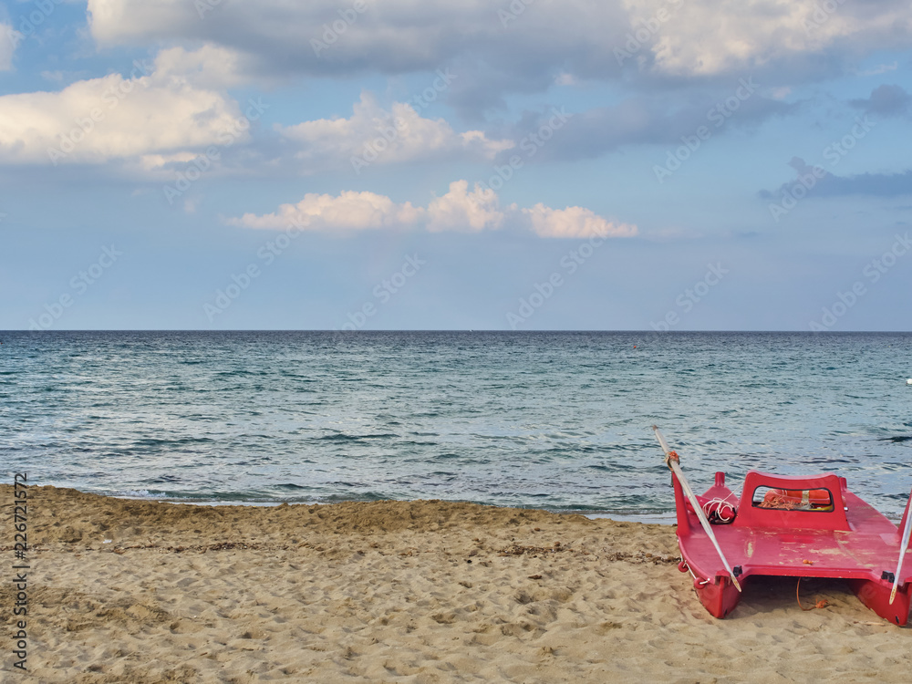 Naklejka premium Shot of the beautiful tropical San Lorenzo beach near Syracuse in a sunny day of summer, with a lifeguard boat parked on the seaside