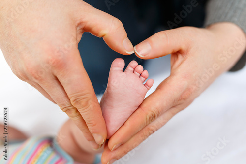 Father or mother holding foot of newborn baby