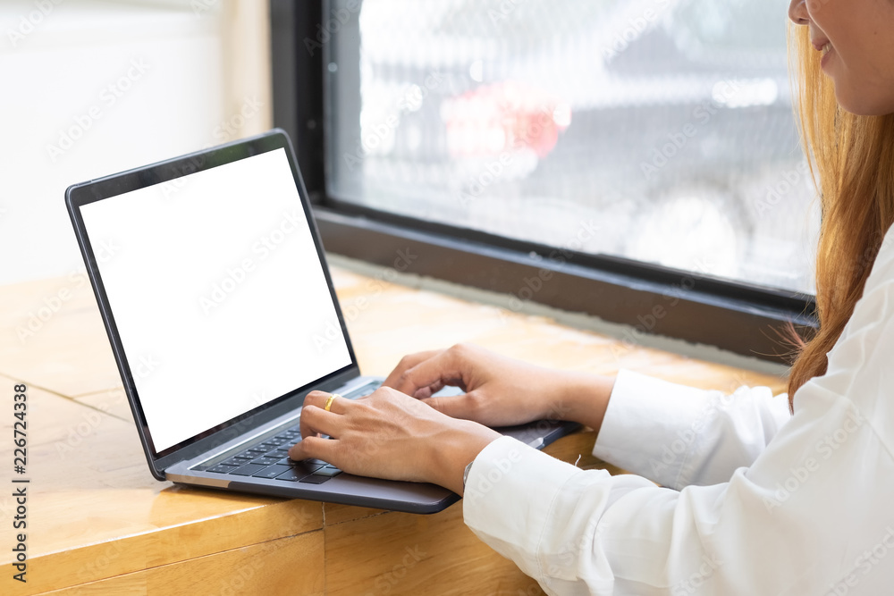 Woman using mockup laptop computer with empty screen display. Woman using mockup laptop computer with empty screen display.