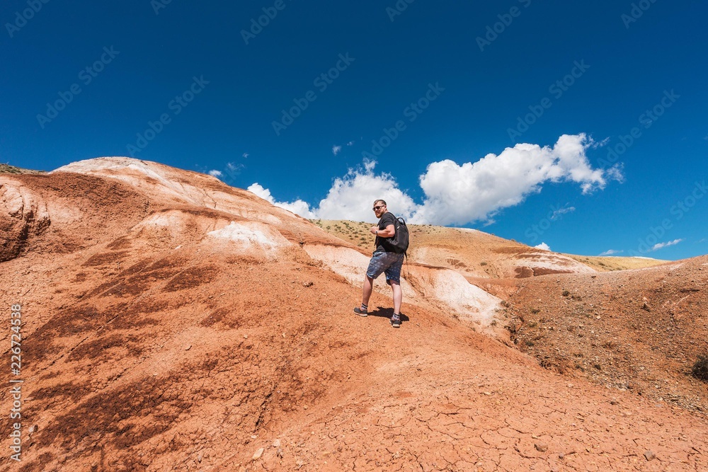 Tourist with a backpack climbs the mountain