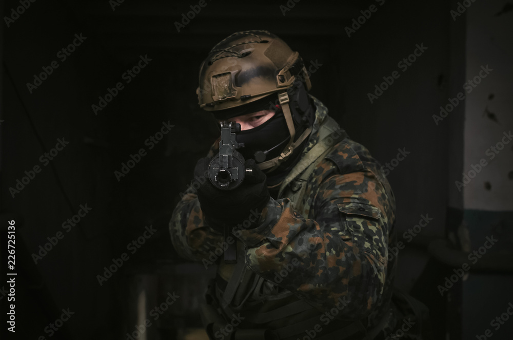 A army soldier takes aim with a rifle in his hands to the screen. Storming the building concept. Front view.