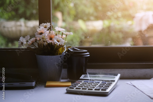 Business home object, calculator, coffee, flower on white table. © Prathankarnpap