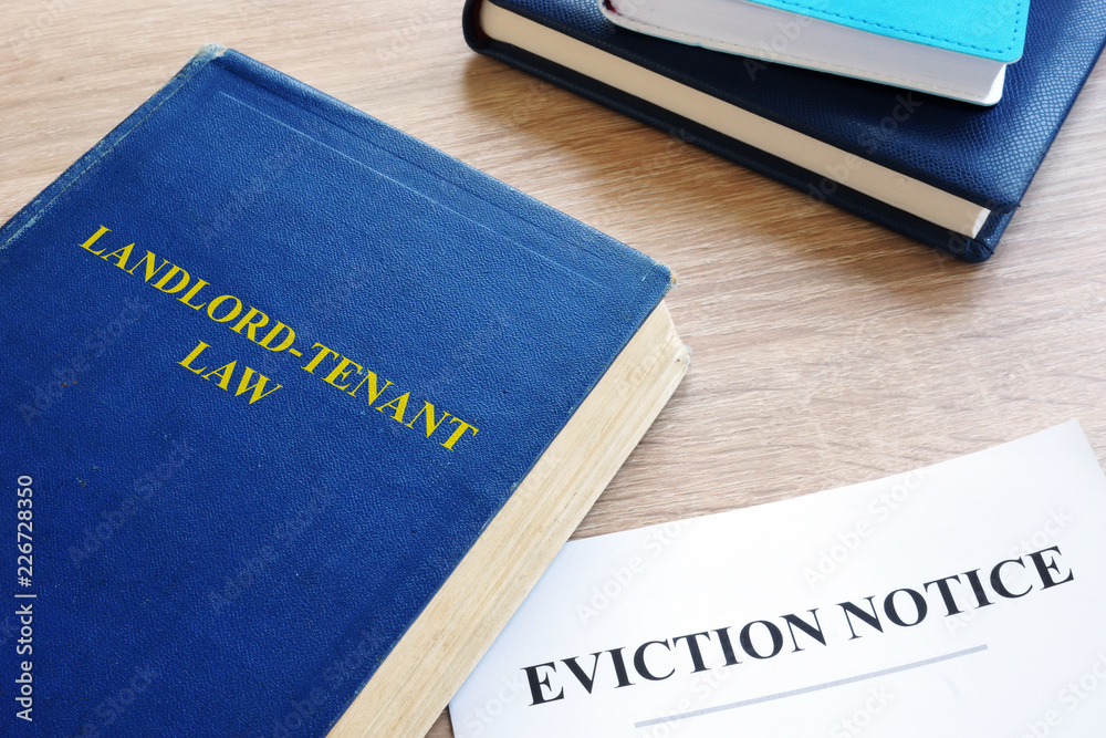 Landlord-Tenant Law and eviction notice on a desk. Landlord-Tenant Law and eviction notice on a desk.