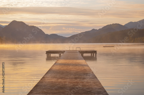 Ein Holzsteg am See im Sonnenaufgang und in Hintergrund Berge    sterreich  Fuschlsee  