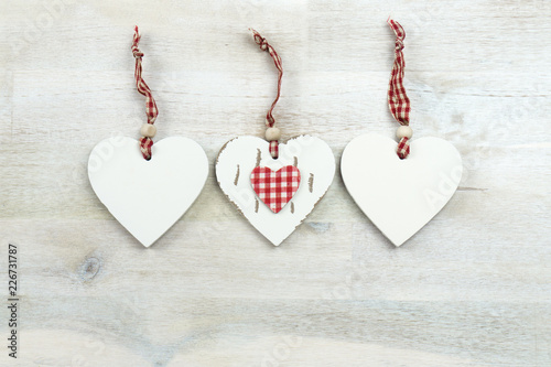 Three hearts of wood on wooden background, copy space