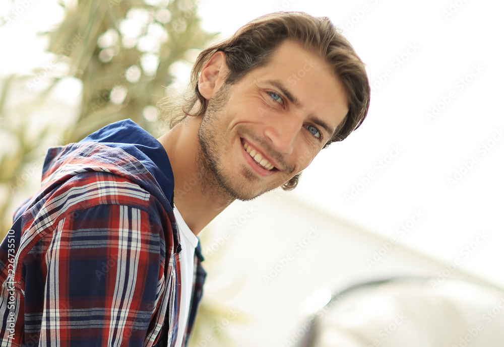 stylish young man working on laptop and looking at camera stylish young man working on laptop and looking at camera