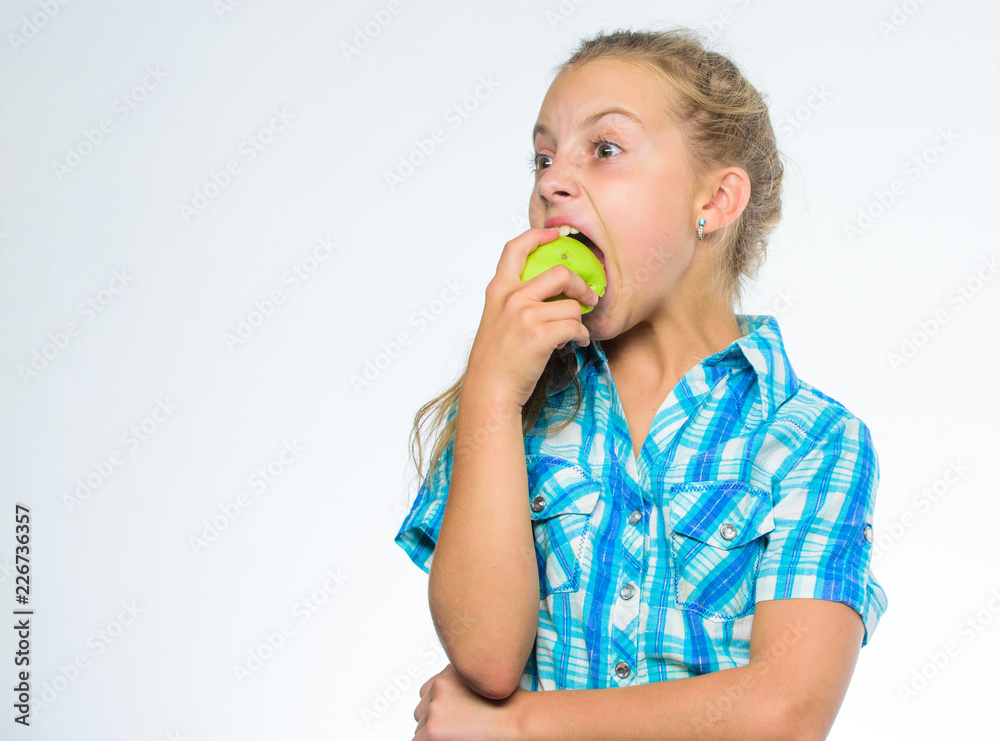 Vitamin nutrition concept. Good nutrition is essential to good health. Find out which vitamins and minerals your body need. Kid girl eat green apple fruit. Nutrition vitamin content of apple Vitamin nutrition concept. Good nutrition is essential to good health. Find out which vitamins and minerals your body need. Kid girl eat green apple fruit. Nutrition vitamin content of apple