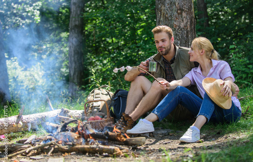 Hike picnic. Couple take break to eat nature background. Couple in love camping forest hike. Couple sit near bonfire eat snacks and drink. Hike snacks and beverages. Food for hike and camping