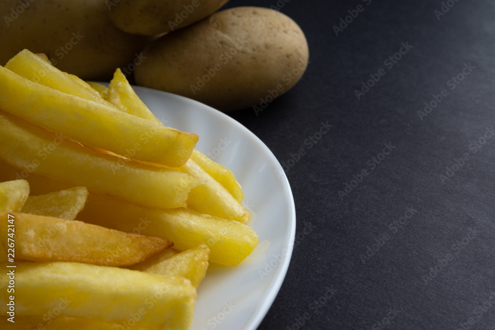 Potato fry on dark background with selective focus and crop fragment Potato fry on dark background with selective focus and crop fragment