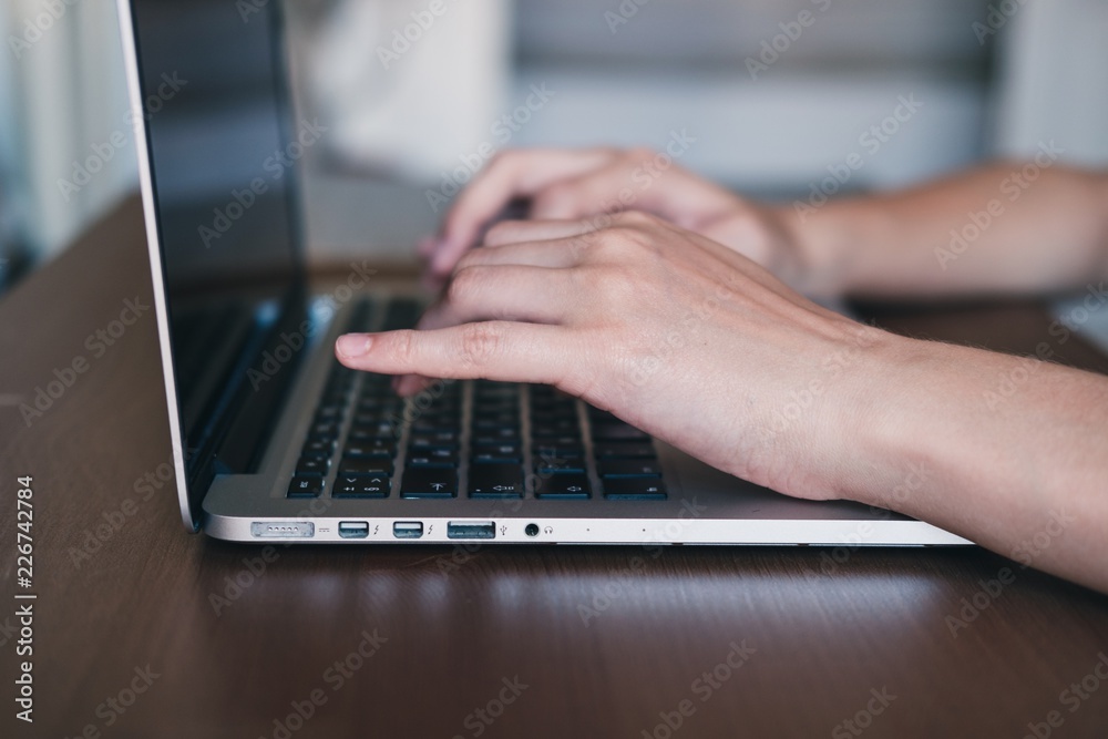 Female freelancer's hands using notebook. Student using laptop for work or study or shopping. Business communication concept. Side view. Female freelancer's hands using notebook. Student using laptop for work or study or shopping. Business communication concept. Side view.