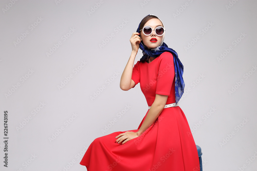 Young woman in retro style. Sunglasses and silk scarf. - obrazy, fototapety, plakaty 