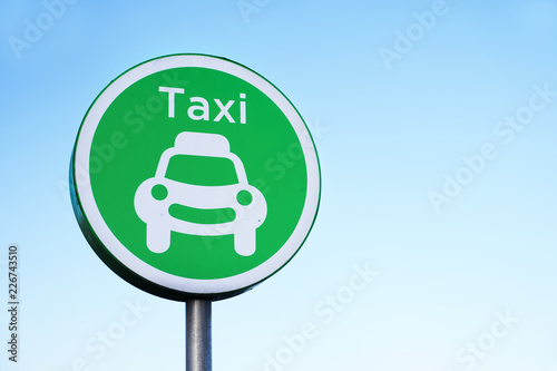 Taxi rank sign and vehicle car symbol against plain blue sky for private transport photo