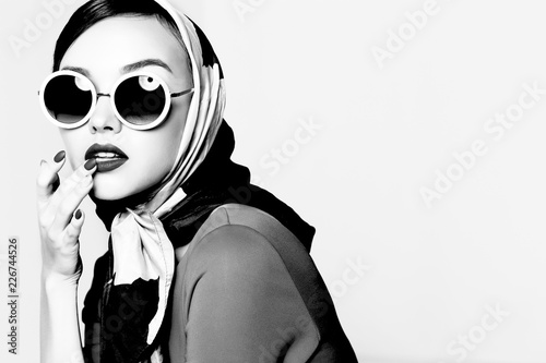 Young woman in retro style. Sunglasses and silk scarf. photo