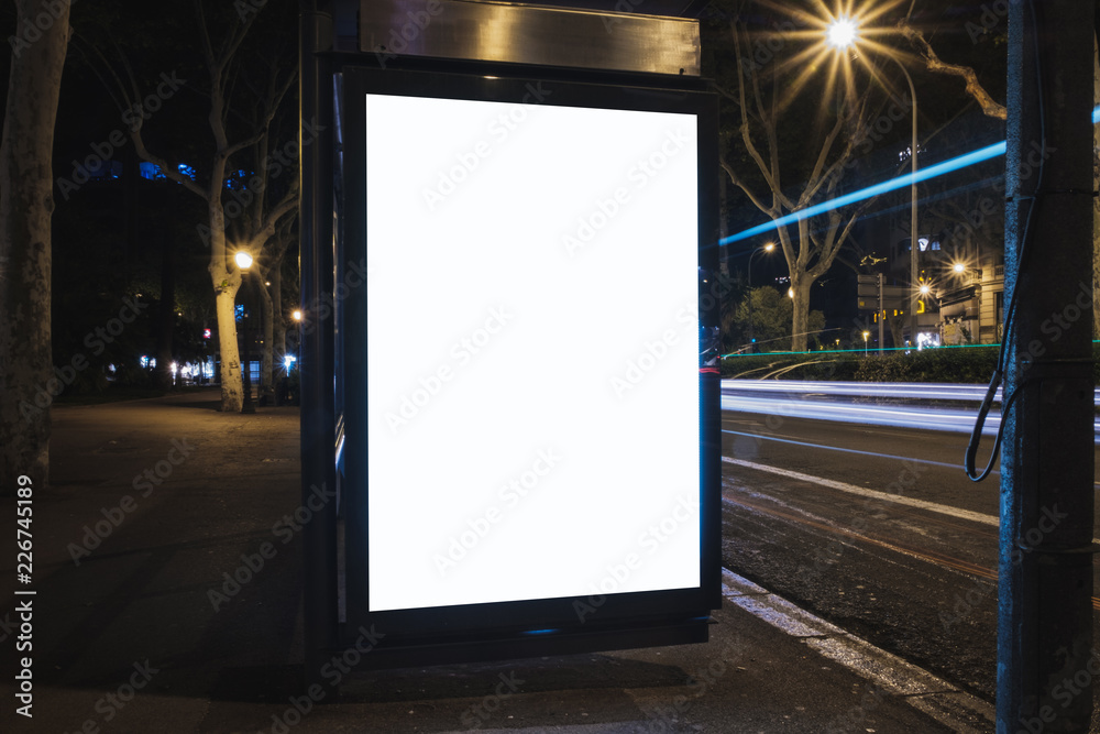Blank white advertisement lightbox at night. Mock-up design concept. Ad board. Car lights.
