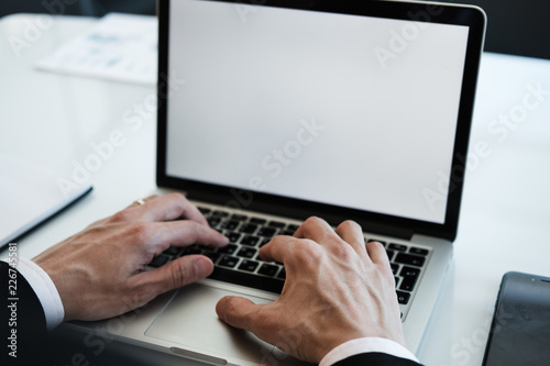 Businessman in black suit and white shirt using laptop for work at office. Using technology for work. Business communication concept. Horizontal.