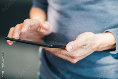 Man's hands holding digital tablet and typing message. Concept of shopping or planning business on touchpad. Businessman using wireless device.