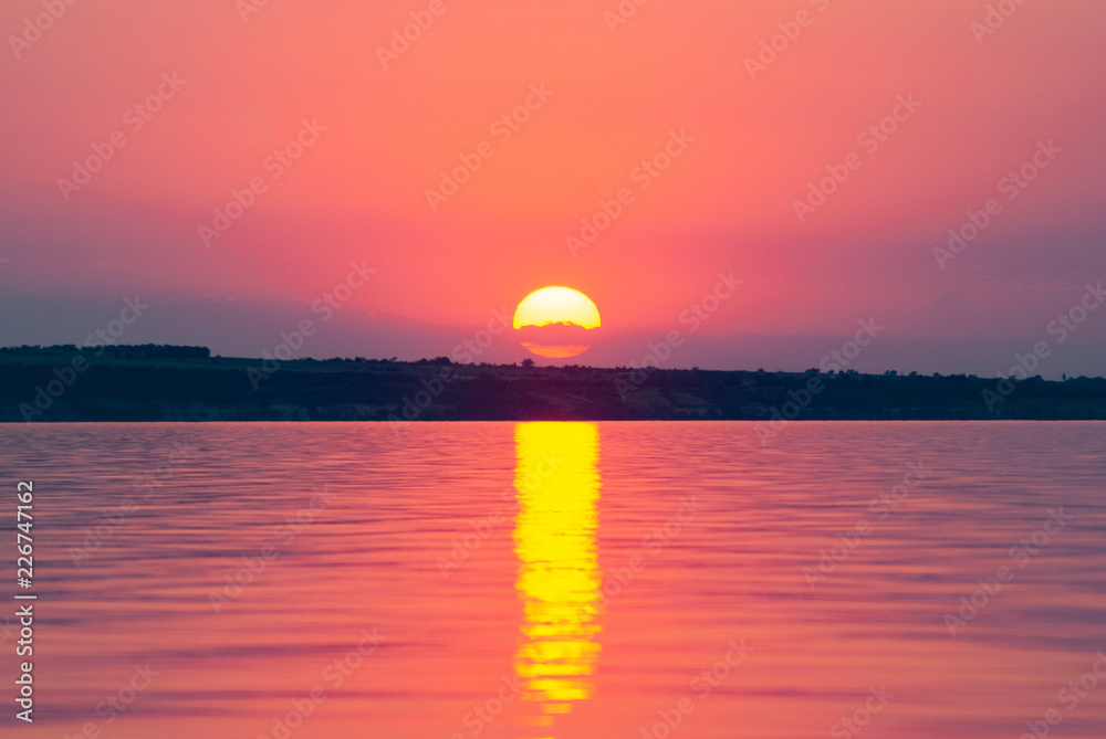The sun is reflected on the waves, warm summer evening, romantic landscape, crimson sunset on the river, The sun is reflected on the waves, warm summer evening, romantic landscape, crimson sunset on the river,