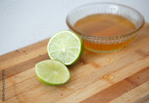 Healthy food. Sliced ​​lime and honey in a transparent plate on a wooden stand