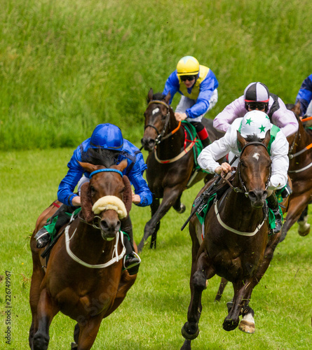 Speeding race horses and jockeys competing
