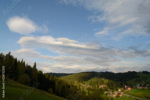 Landscape area  village houses  firs  pines  trees  mountains  hills  sunset . Nature and man. Natural background.