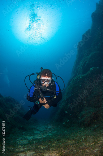 Scuba diver underwater in the deep blue ocean and backlight sun. © frantisek hojdysz