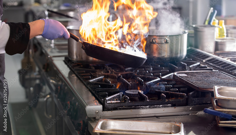 Chef in hotel or restaurant kitchen cooking
Chef in hotel or restaurant kitchen cooking