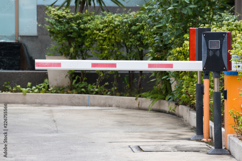 Fototapeta premium security barrier system at the gate of car park background, red and white steel Rising Arm Access Barrier
