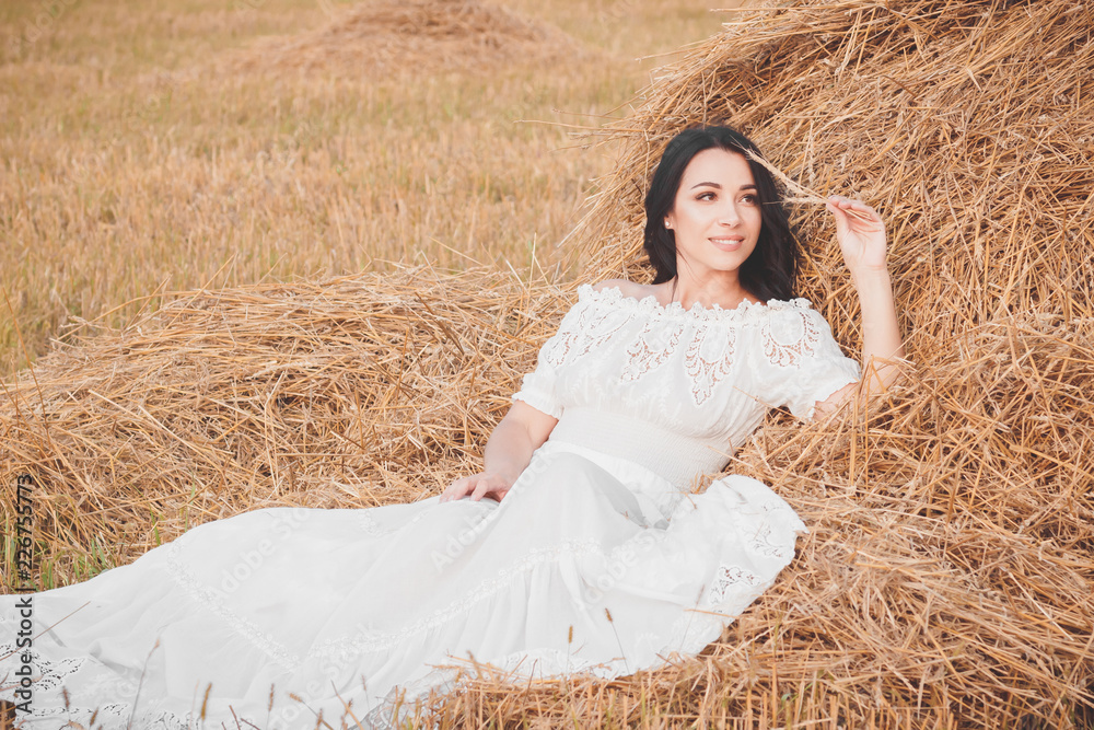 Beautiful young woman on the dried haystack Beautiful young woman on the dried haystack