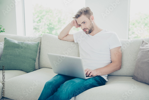 Online shopping concept. Portrait of calm, concentrated man sitt