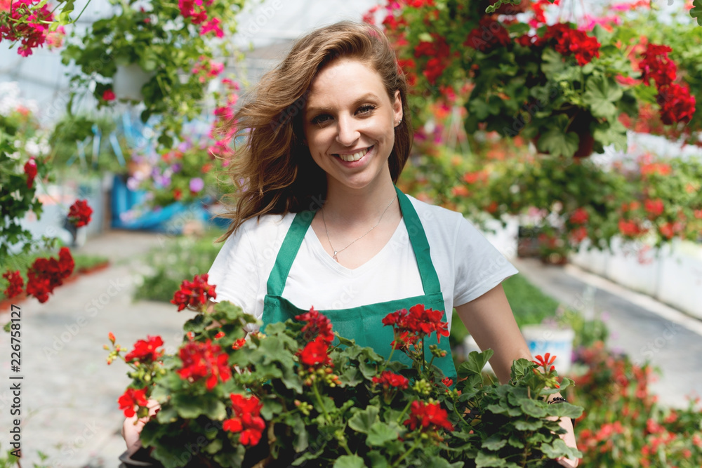 Smiling Young florist in greenhouse
