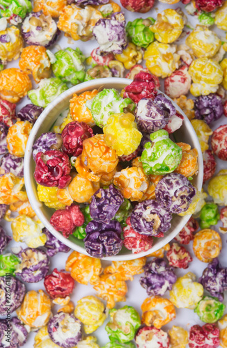 a bucket of multi-colored popcorn in the background, scattered sweet dessert