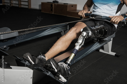 Crop disabled man on rowing machine