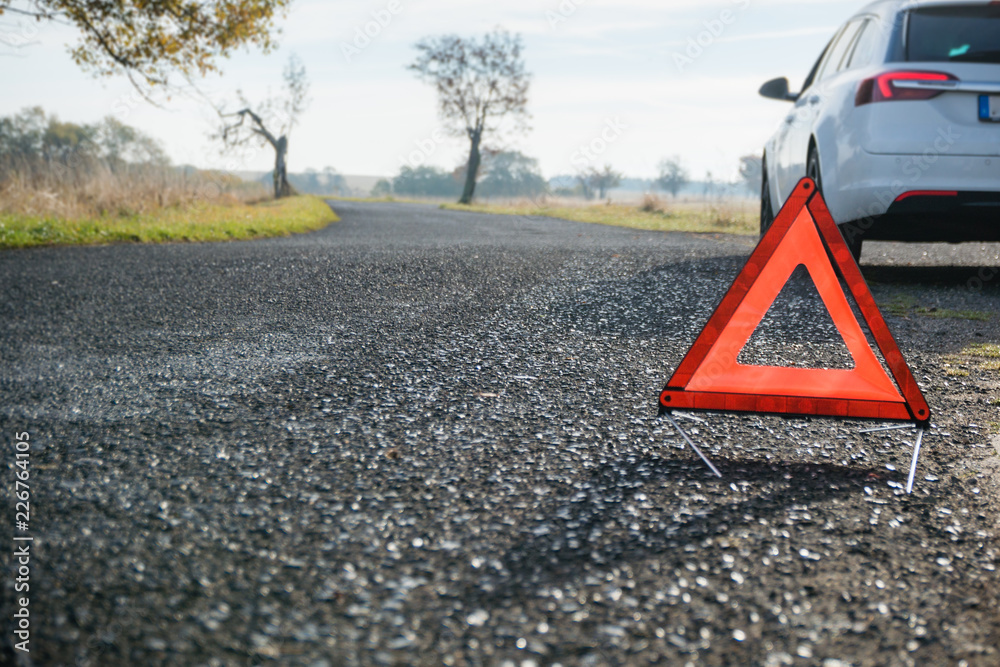 Obraz premium Auto mit Warndreieck am Straßenrand