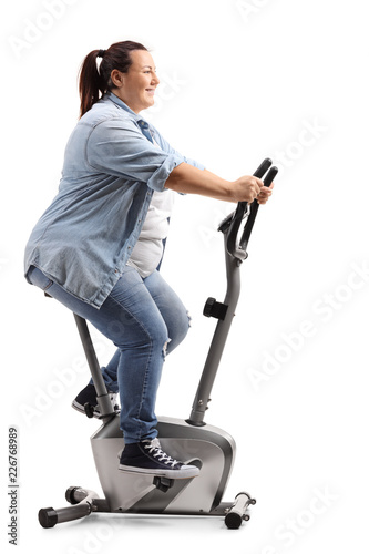 Overweight woman exercising on a stationary bicycle