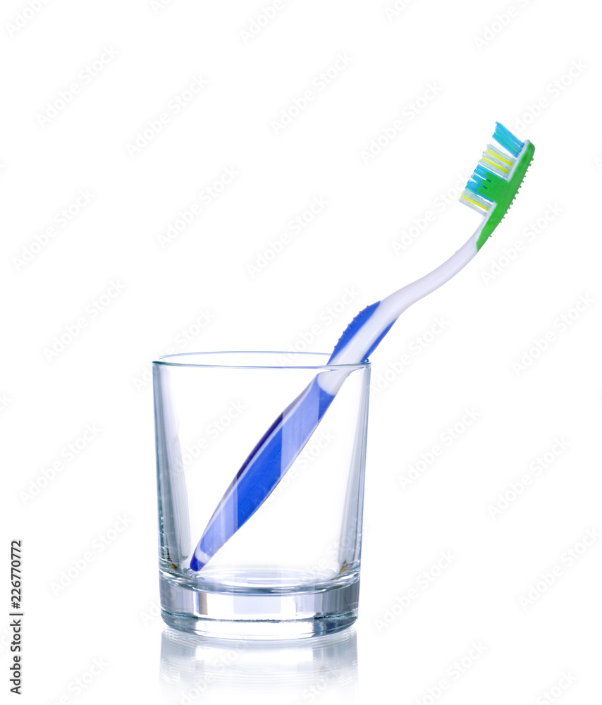 One tooth brushes in glass, isolated on white One tooth brushes in glass, isolated on white