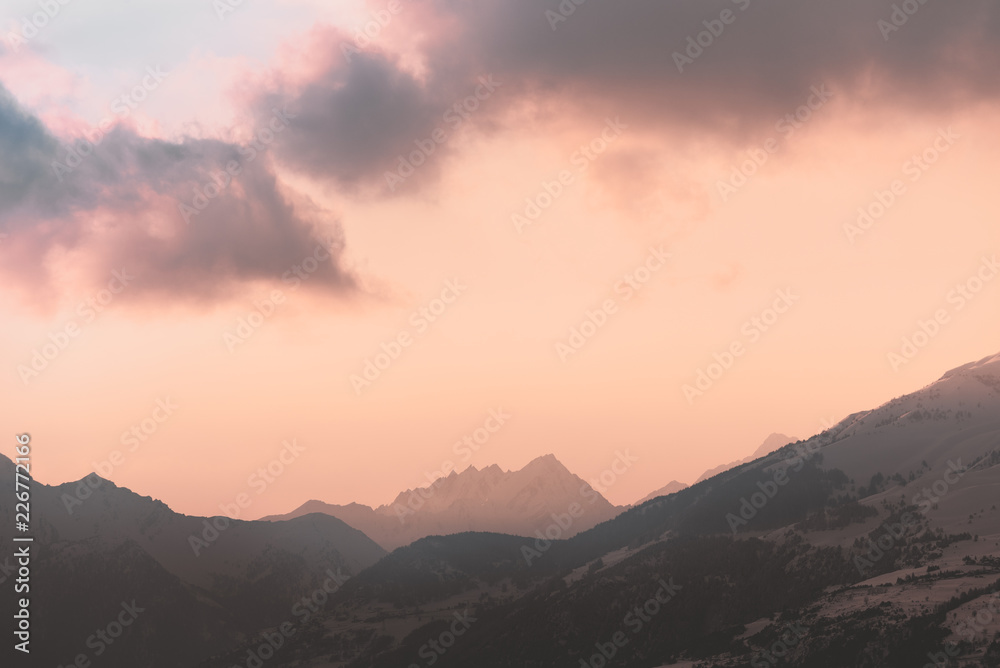 Red cloud over distant mountains