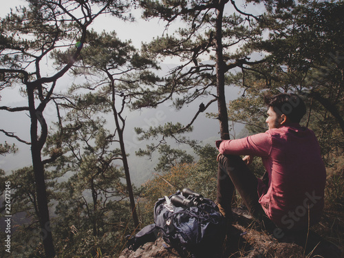 The tourist sitting relaxed on mountain.