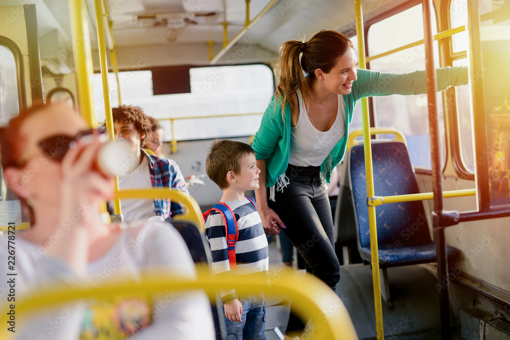 Picture of cute little boy in a bus. Holding his mothers hand and ...