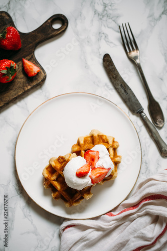 Belgian waffles with ice cream and berry fruits on white background, homemade healthy breakfast 