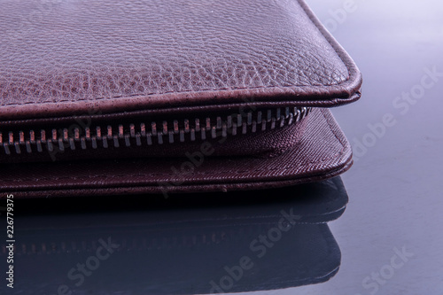 A brown men's leather wallet with reflection.