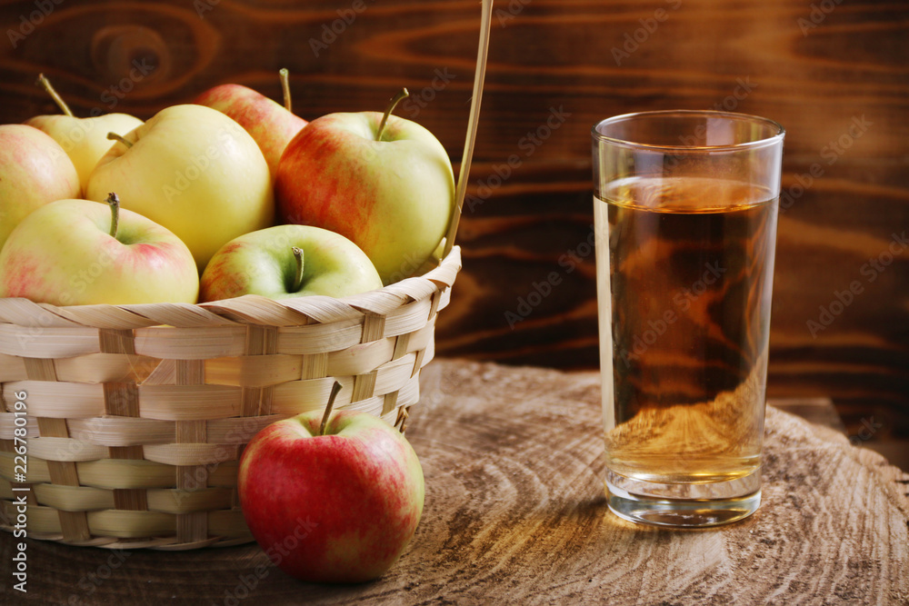 Apple cider in glass with basket of seasonal apple Apple cider in glass with basket of seasonal apple
