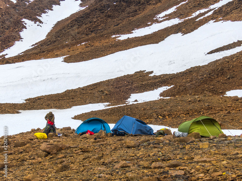 Tourist tents in the mountains. Beautiful mountain landscape, panorama. Snowy peak. Polar urals mountains. Yamal